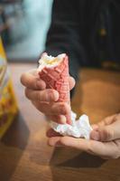 tasty cold creamy vanilla ice cream in a red sugar cone held in your hand photo