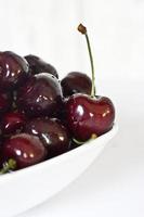 l juicy fresh summer cherries in a white bowl on a vintege background photo