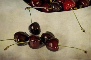 l jugoso Fresco verano cerezas en un blanco cuenco en un vintege antecedentes foto