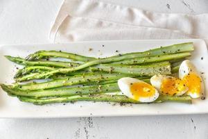 Bunch of cooked asparagus with egg photo