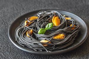 Black pasta with mussels and parmesan photo