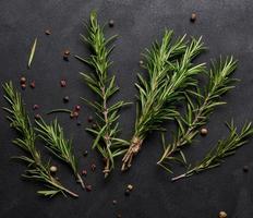 Sprigs of fresh rosemary on a black background, top view photo