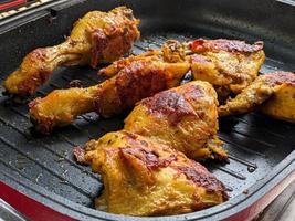 the process of roasting chicken meat in a grill pan photo