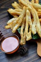 A plate of Cakwe or Cakue with chilli sauce at wooden table. Cakwe is a popular traditional snack from Chinese and indonesia photo