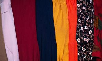 Rows of colourful silk scarfs hanging at a market photo