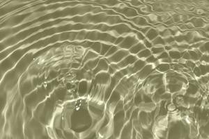 Defocus blurred transparent cream colored clear calm water surface texture with splashes and bubbles. Trendy abstract nature background. Water waves in sunlight with copy space. Cream water shine photo