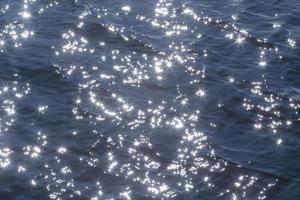 Brillo Solar en azul olas de río foto