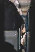 Interior of empty modern aircraft with blue flight seats and hallway in daytime during flight photo