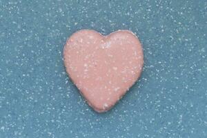 pink valentine shaped cookie on abstract plastic background photo