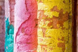 Red, Orange, yellow and blue color combination old Textured damage wall with Colorful Bricks. photo