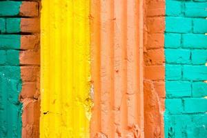 Red, Orange, yellow and blue color combination old Textured damage wall with Colorful Bricks. photo