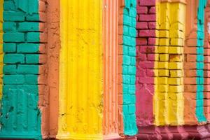 Red, Orange, yellow and blue color combination old Textured damage wall with Colorful Bricks. photo