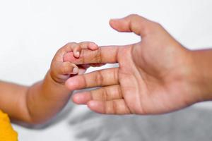 A asian baby's hand holding her mother finger photo