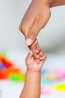 A asian baby's hand holding her mother finger photo