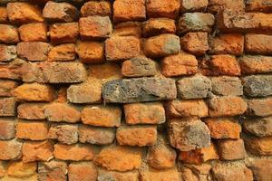 Old orange and red breakable brick arch wall with pattern. photo