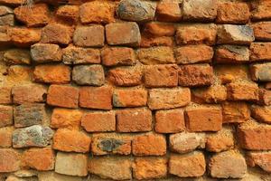 Old orange and red breakable brick arch wall with pattern. photo