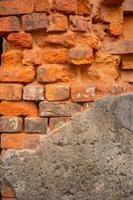 Old orange and red breakable brick arch wall with pattern. photo