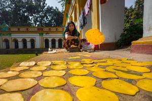 Bangladesh marzo 02, 2019, un pequeño negocio mujer haciendo en hecho a mano papor frito un pan a dinajpur palacio, dinajpur, bangladesh foto