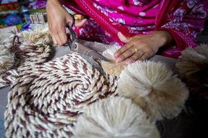 A woman making handicrafts is smoothing the fibers of a banana tree with scissors in Madhupur, Tangail, Bangladesh. photo