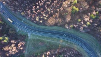 Visualizza a partire dal il altezza di il traffico su il strada circondato di autunno foresta video