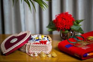 Handmade fiber ornaments box with traditional jewelry on the wooden table. Indian traditional jewelry and Bridal saree. photo