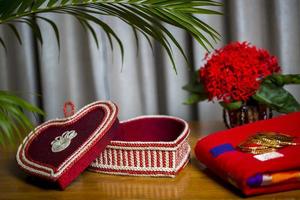 Handmade fiber ornaments box with traditional jewelry on the wooden table. Indian traditional jewelry and Bridal saree. photo