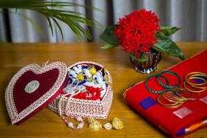 Handmade fiber ornaments box with traditional jewelry on the wooden table. Indian traditional jewelry and Bridal saree. photo