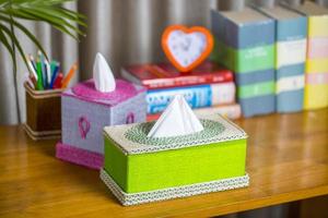 A tissue box on a wooden reading table. A tissue box made of fiber. Pineapple leaf fiber. photo