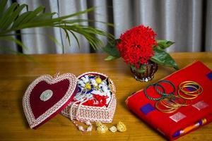 Handmade fiber ornaments box with traditional jewelry on the wooden table. Indian traditional jewelry and Bridal saree. photo