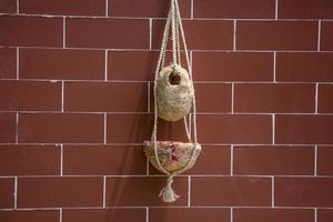 hecho a mano aves nido son colgando en el ladrillos pared. interior decoración diseño. nido hecho de fibra. foto