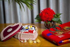 Handmade fiber ornaments box with traditional jewelry on the wooden table. Indian traditional jewelry and Bridal saree. photo