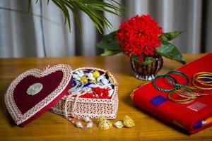 Handmade fiber ornaments box with traditional jewelry on the wooden table. Indian traditional jewelry and Bridal saree. photo