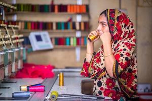 Bangladesh August 6, 2019, A Bangladeshi woman garments worker working with Computerized Embroidery Machine at Madhabdi, Narsingdi, Bangladesh. photo