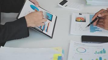 Financial analysts analyze business financial reports on a digital tablet planning investment project during a discussion at a meeting of corporate showing the results of their successful teamwork. video