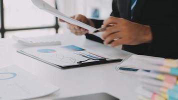Financial analysts analyze business financial reports on a digital tablet planning investment project during a discussion at a meeting of corporate showing the results of their successful teamwork. video