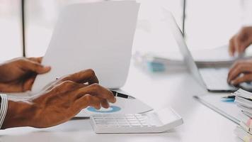 Financial analysts analyze business financial reports on a digital tablet planning investment project during a discussion at a meeting of corporate showing the results of their successful teamwork. video