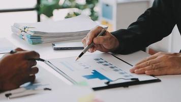 Financial analysts analyze business financial reports on a digital tablet planning investment project during a discussion at a meeting of corporate showing the results of their successful teamwork. video