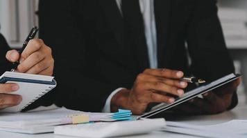 Financial analysts analyze business financial reports on a digital tablet planning investment project during a discussion at a meeting of corporate showing the results of their successful teamwork. video