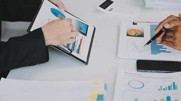 Financial analysts analyze business financial reports on a digital tablet planning investment project during a discussion at a meeting of corporate showing the results of their successful teamwork. video