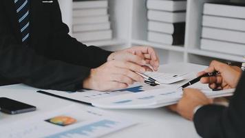 Financial analysts analyze business financial reports on a digital tablet planning investment project during a discussion at a meeting of corporate showing the results of their successful teamwork. video
