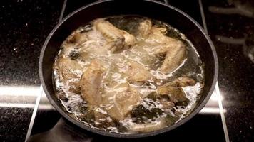 Koken werkwijze van koken kip, de maken van kip soep net zo een maaltijd in een elektrisch fornuis met een marmeren pan. video
