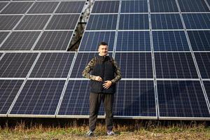 hombre en el antecedentes de solar paneles eco energía. foto