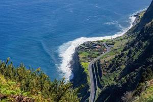 Scenic view of a winding road along a steep cliffside overlooking the ocean photo