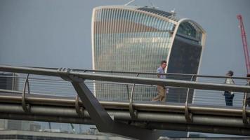 lasso di tempo di il Londra orizzonte e persone attraversamento il millennio ponte al di sopra di il fiume Tamigi video