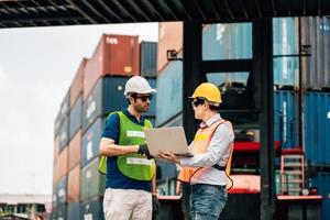 Team Engineer and worker wear safety uniform check control loading freight cargo container use computer laptop at commercial dock warehouse,transportation import,export logistic industrial service photo
