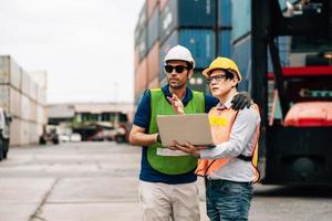 Team Engineer and worker wear safety uniform check control loading freight cargo container use computer laptop at commercial dock warehouse,transportation import,export logistic industrial service photo