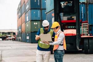 Team Engineer and worker wear safety uniform check control loading freight cargo container use computer laptop at commercial dock warehouse,transportation import,export logistic industrial service photo
