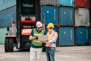 Team Engineer and worker wear safety uniform check control loading freight cargo container use computer laptop at commercial dock warehouse,transportation import,export logistic industrial service photo