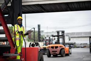 engineer man worker in safety jumpsuit uniform with yellow hardhat and use laptop computer control at cargo container ship port warehouse.transport import,export logistic industrial service photo