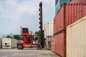 máquina elevadora cargando envase caja para logístico importar exportar y transporte negocio industria.carga camión envase transporte en un carga Embarcacion con industrial grua. foto